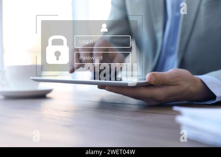 Privacy protection. Man using tablet in office, closeup. Digital login interface over device Stock Photo