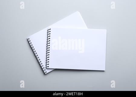 Notebooks on light grey background, top view. Space for text Stock Photo