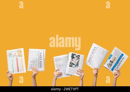 Women with newspapers on yellow background Stock Photo
