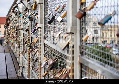 a row of different sized padlocks on the bridge railing Stock Photo