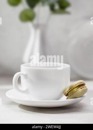 Coffee cup and one macaroon on the table with copy space at the top of the frame Stock Photo