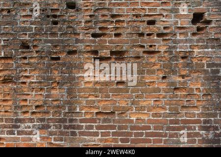 Background from an old brick wall with bricks falling out in some places Stock Photo