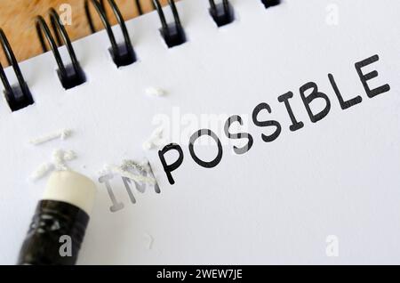 Pencil eraser erasing impossible into possible. Motivational and inspirational concept. Stock Photo