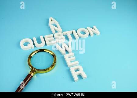 Question and Answer alphabet letters with magnifying glass on blue background Stock Photo