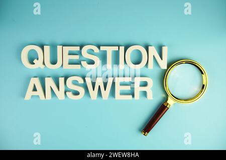 Question and Answer alphabet letters with magnifying glass on blue background Stock Photo