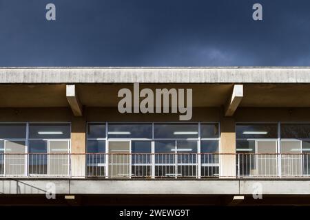 Windows and balconies on a flat-roofed old school building  under a brooding sky. Kanagawa, Japan. Stock Photo