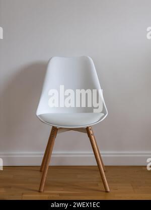 White chair against blank wall Stock Photo