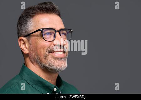 Smiling middle aged business man wearing stylish eyeglasses isolated on gray. Stock Photo