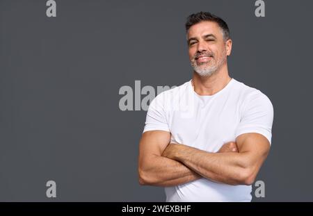 Happy fit sporty older man personal trainer isolated on gray, portrait. Stock Photo