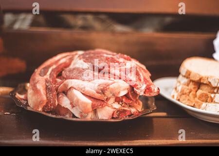 several raw beef entrecote on a silver tray, with the bread next to it Stock Photo