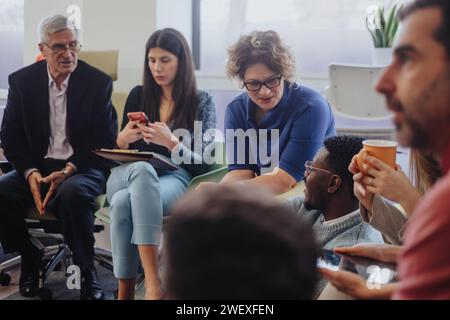Diverse business team brainstorming in a modern co-working space, sharing ideas for better efficiency and successful results. Stock Photo