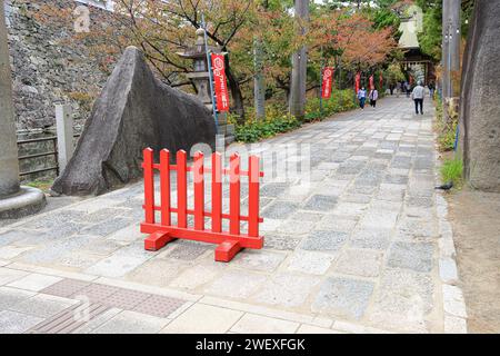 The red fence forbids vehicles from approaching the walkway leading to the Sarutahikosha shrine in Fukuoka, Japan. Stock Photo