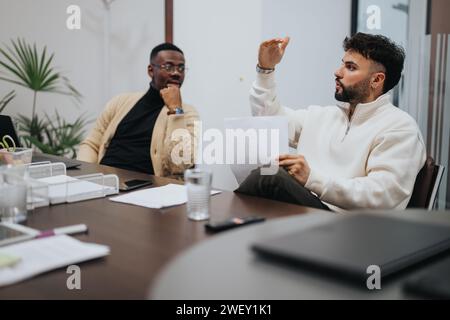 Male person explaining something during meeting in modern boardroom. He gestures with his hand. Stock Photo