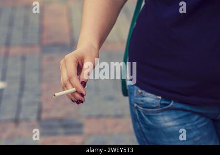 The woman, girl holds a cigarette in hand. Dependence on an addiction. Before smoking. Smoking concept, smoker. close-up Stock Photo