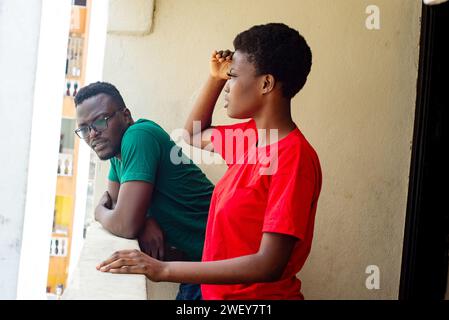Beautiful young happy couple standing relaxing and having fun on the balcony of the house. Stock Photo