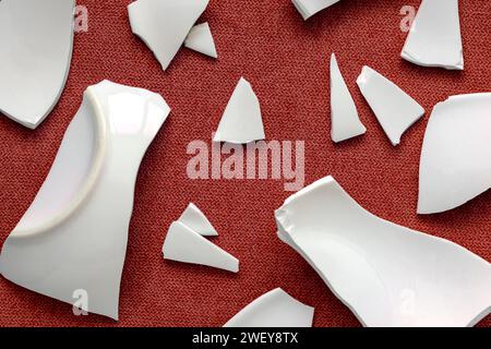 Splinters and Fragments of the broken white ware. Broken Plate, glass.  Pieces of shattered dishes. close-up, top view Stock Photo