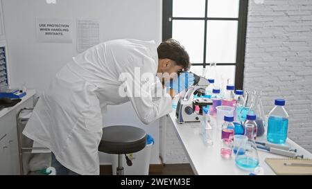 Young arab man scientist using microscope at laboratory Stock Photo