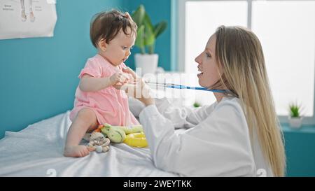 Mother and daughter pediatrician examining baby chest at clinic Stock Photo
