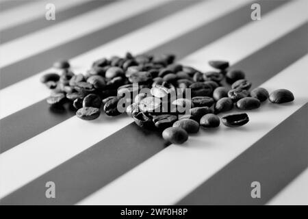 Black and white photo of coffee beans on striped tabletop Stock Photo