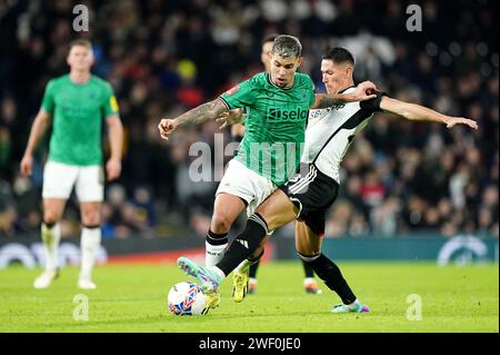 Newcastle United's Bruno Guimaraes (left) and Fulham's Sasa Lukic battle for the ball during the Emirates FA Cup fourth round match at Craven Cottage, London. Picture date: Saturday January 27, 2024. Stock Photo