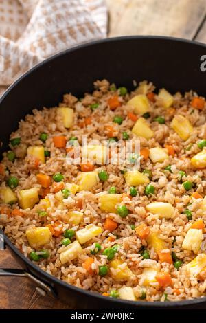 Pineapple fried rice with eggs, carrots and peas in a skillet Stock Photo