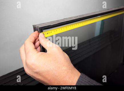 Using measurement tape, measuring tool for glass. Home construction Stock Photo