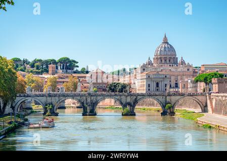 Ponte Sant'Angelo (St. Angelo Bridge) that spans the Tiber river, with the dome of Saint Peter's Basilica in the background. Stock Photo