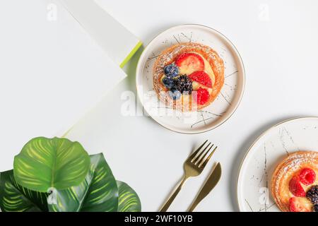 Flat lay composition with delicious berry tartlets on a white background Stock Photo