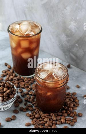 Two Glass of Homemade Iced Americano Coffee with Beans on Cement Grey Background Stock Photo