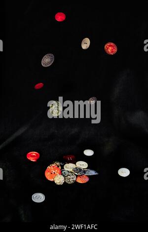 buttons falling on a black velvet background Stock Photo