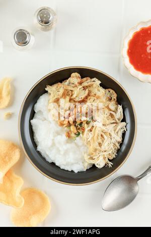 Top View Bubur Ayam or Chicken Porridge, Indonesian Traditional Food Consist of White Rice Porridge, Shredded Chicken, Cakwe, Fried Soybean, and Green Stock Photo