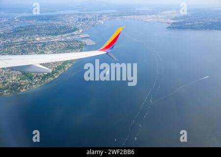 Seattle, USA - Jul 30 2023: Southwest Airlines airplane flying towards Seattle. Aerial view of Seattle cityscape. Stock Photo