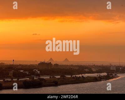 Beijing, Egypt. 27th Jan, 2024. This photo shows the sunset moment at the Nile River with Giza Pyramids in the distance, in Cairo, Egypt, on Jan. 27, 2024. Credit: Wang Dongzhen/Xinhua/Alamy Live News Stock Photo