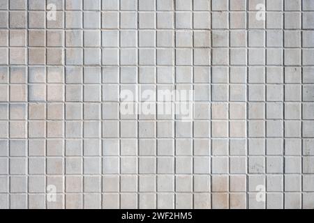 Background from a wall made of square beige mosaic tiles Stock Photo