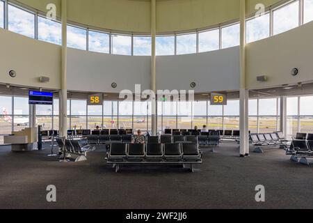 A waiting lounge in Sydney Airport Domestic Terminal 2, with views through large windows onto the runway, Sydney, New South Wales, Australia Stock Photo
