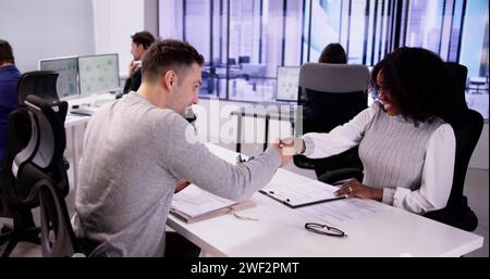 Smiling Young Man Shaking Hands With Female At Interview Stock Photo
