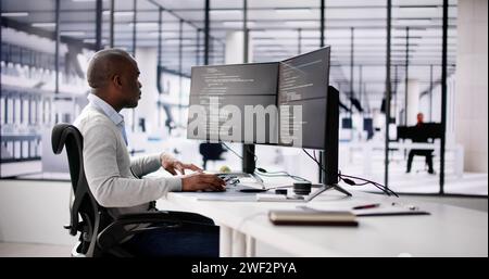 African American Coder Using Computer At Desk. Web Developer Stock Photo