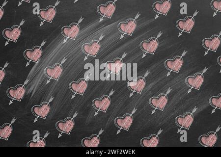 Pattern with hearts and Cupid's arrows drawn on the blackboard. Love, romance, valentine day. Stock Photo