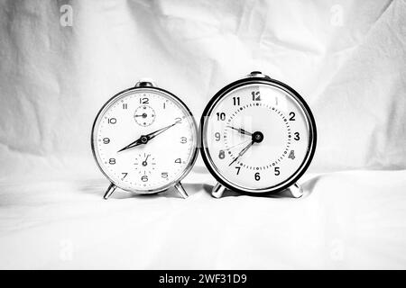 Two retro alarm clocks in black and white on white background Stock Photo