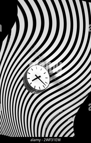 Clock in black and white on bent striped pattern Stock Photo