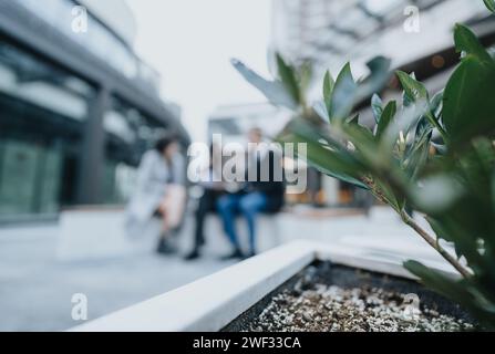 A selective focus shot capturing the essence of contemporary corporate interactions, with unrecognizable businesspeople conversing outdoors. Stock Photo