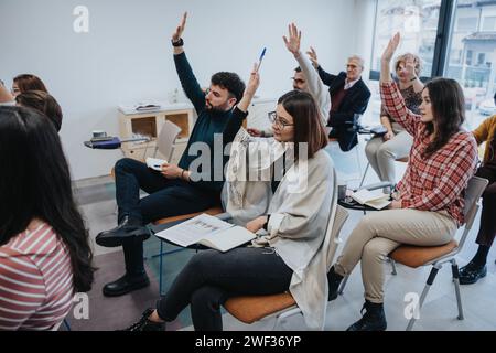 Colleagues, learners participating training session, sitting in chairs arranged in a semi-circle and raising their hands to answer a question. Stock Photo