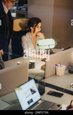 Focused female professional in meeting with senior colleague at office. Stock Photo