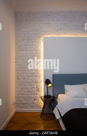 Interior of a modern bedroom with a white brick wall and a bed Stock Photo
