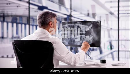 Dentist Doctor Looking At Teeth Xray On Computer Stock Photo