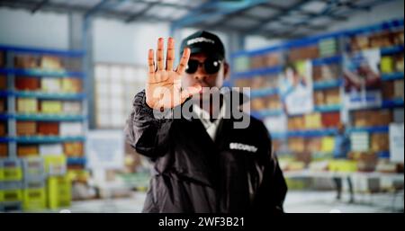 Security Guard In Logistic Business Distribution Warehouse Making Stop Gesture Stock Photo