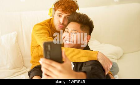 Gay couple embracing and smiling while taking selfie together Stock Photo