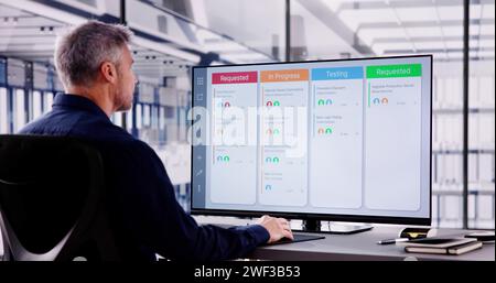 Scrum Project Manager Using Scrum Board Scheduling Software Stock Photo