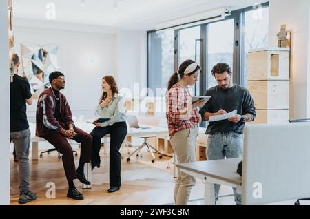 Young business professionals have a productive meeting, discussing strategies and analyzing reports in a modern office. Stock Photo