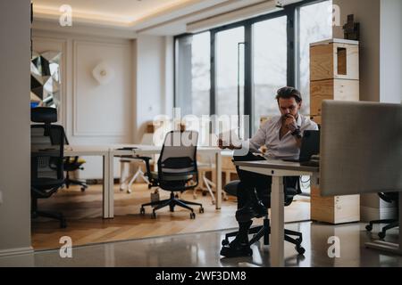 Focused young entrepreneur analyzing documents in a modern office Stock Photo